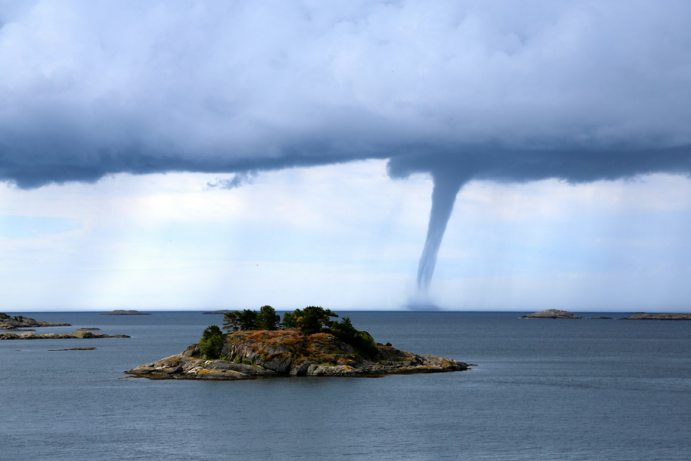Image: a tornadic waterspout bears down on a small island in the waters near Arendal, Norway.