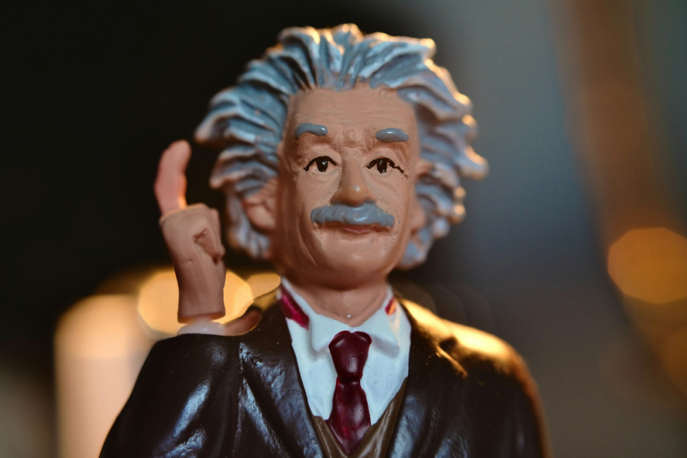 Image: a small, painted statuette of Albert Einstein